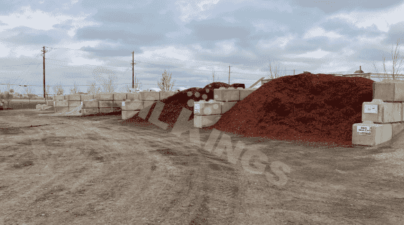 Red mulch piles for garden landscaping and decorative ground cover applications.
