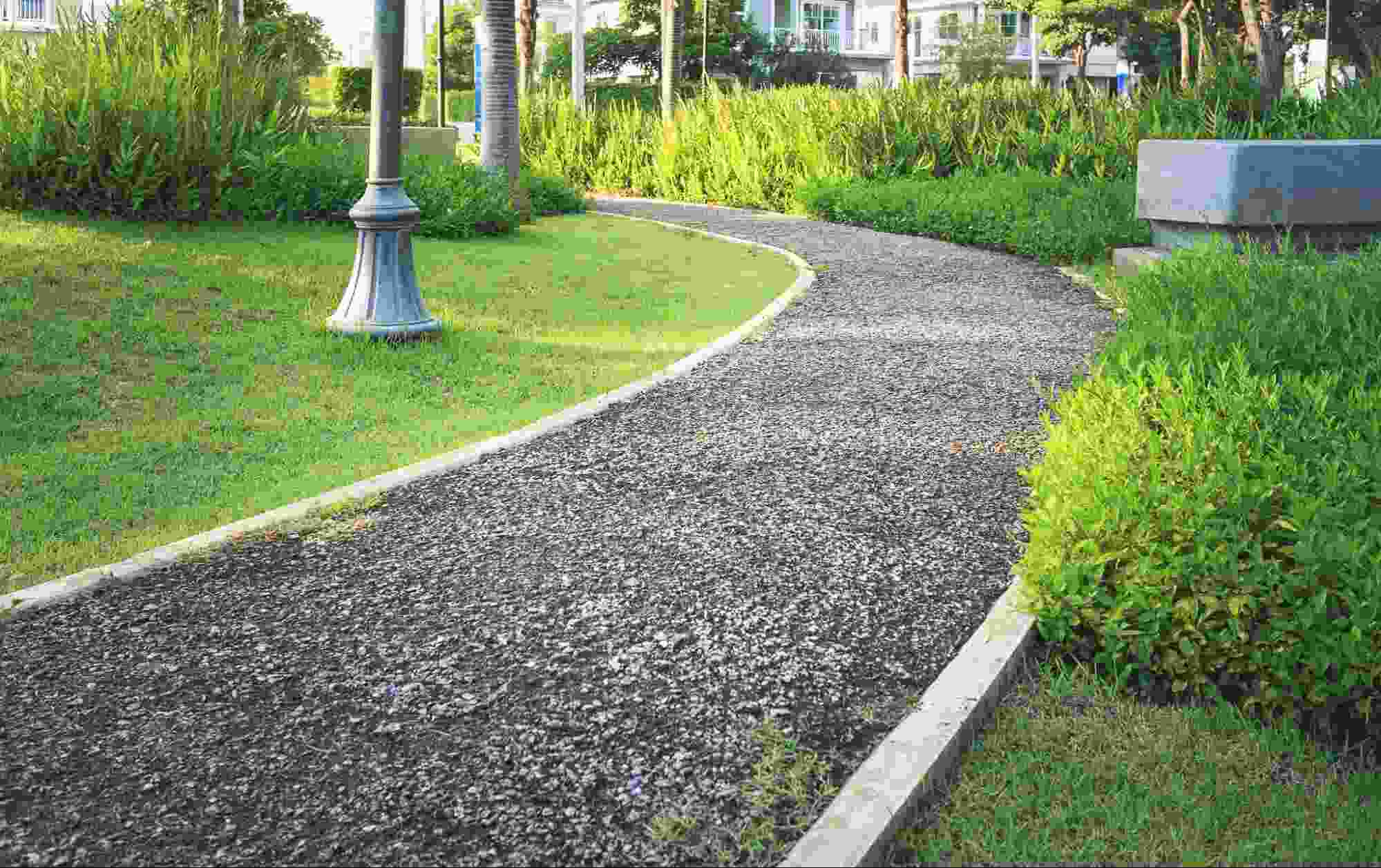 Curved pathway constructed with compacted rundle fines and bordered by landscaping, illustrating the smooth walking surface and natural appearance often compared in discussions of rundle fines vs rundle rock.
